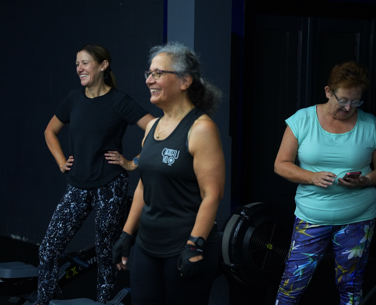3 women in their 50s and 60s smiling in their personal training session